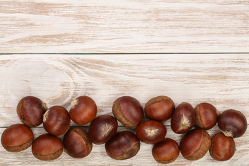 chestnut on white wooden background with copy space for your text. Top view. Flat lay.