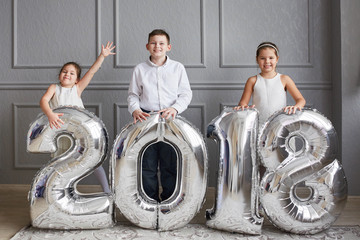 Obraz na płótnie Canvas three children with large numbers 2018