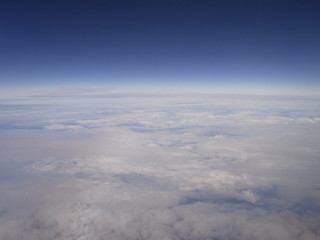 Fototapeta na wymiar 飛行機の窓から見た空と雲