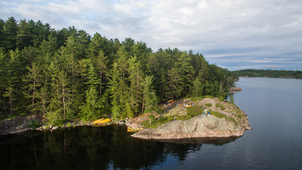 Fototapeta premium Aerial view of camping on the edge of a river during a family canoe trip