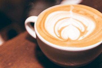 Coffee latte art on wooden table in coffee shop