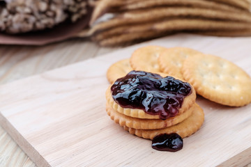 Cracker with jam on woodden background