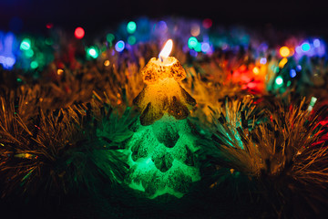 Obraz na płótnie Canvas Burning candle and Christmas decoration. Elegant low-key shot with festive mood