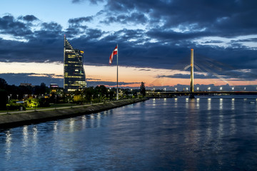 Fototapeta premium View of the cable-stayed bridge and the embankment of the river Daugava in Riga at sunset.