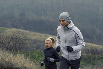 Young couple jogging in nature at cold day