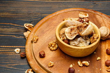 Fototapeta na wymiar dried figs and nuts on wooden background
