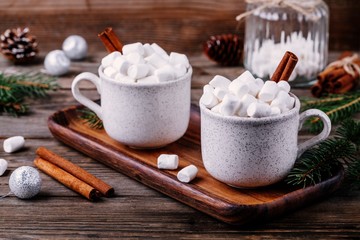 Christmas drink. Hot chocolate with marshmallows and cinnamon on dark wooden background.