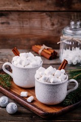Fototapeta na wymiar Christmas drink. Hot chocolate with marshmallows and cinnamon on dark wooden background.