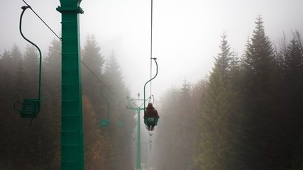 Person on the skilift in foggy weather.