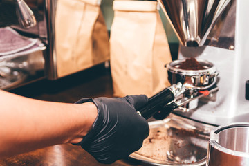 Women Barista using coffee machine for making coffee in the cafe
