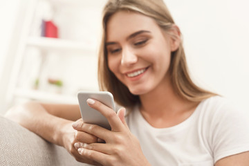 Fototapeta na wymiar Girl at home chatting online on smartphone