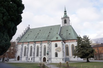 Fototapeta premium Schwaz Tirol Österreich Pfarrkirche Maria Himmelfahrt mit Glockenturm, Stadtpark, Lichtsäule und Grafenbogen