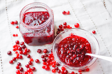 Jam bank with berries top view on a white tablecloth