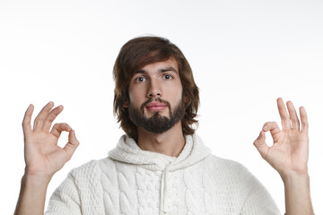Sing, symbols, gestures and body language concept. Headshot of friendly looking positive young European male in knitted sweater showing ok gesture at camera as sign of understanding or approval