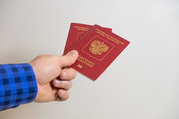 a man holds out two foreign passports of the Russian Federation