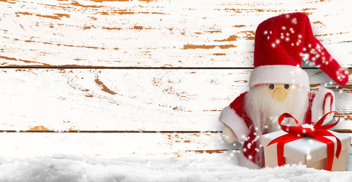 weihnachtsmann mit weihnachtsgeschenk, rustikaler hintergund