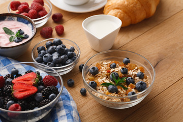 Continental breakfast with croissants and berries on natural wood
