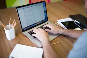 Man business planning expert working on laptop computer. Male content writer for financial  presentation using modern notebook. Hipster guy skilled e-book writer using net-book, sitting at desktop
