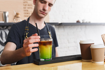 Concentrated bartender making coffee cocktail at cafe counter