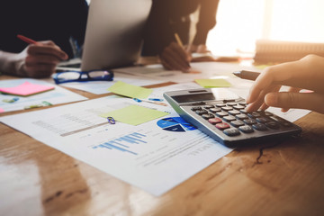 Business People Meeting Corporate Communication with using calculator, pen, notebook and graph chart in at office. Teamwork Concept