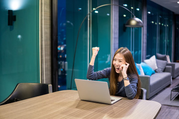 Beautiful Asian girl celebrate with laptop, using hands in different positions, education or technology or startup business concept, modern office or living room with copy space