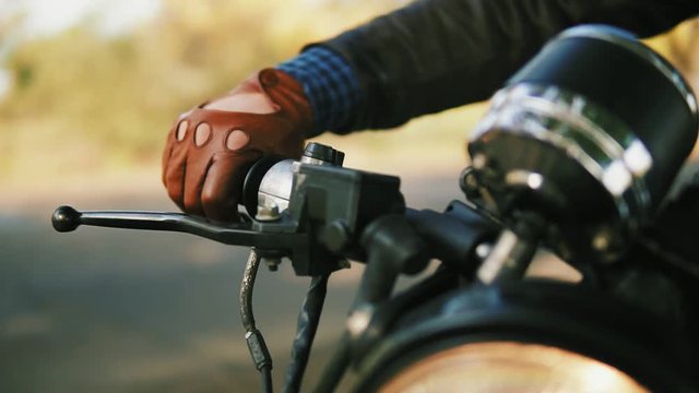 Closeup view of a man's hand in brown leather mitts starting the engine. Slowmotion shot