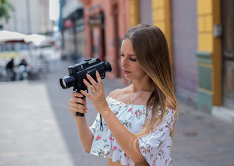 Tenerife. Spain. Cute blonde girl is observing and  filming streets in Santa Cruz de Tenerife. Girl travels concept. Travel to Canary Islands.