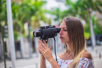 Tenerife. Spain. Cute blonde girl is observing and  filming streets in Santa Cruz de Tenerife. Girl travels concept. Travel to Canary Islands.