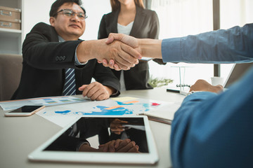 Business Team Meeting Handshake Applaud Concept. Business partners handshaking over business objects on workplace.
