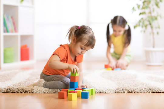 Children toddlers girls playing toys at home, kindergarten or nursery