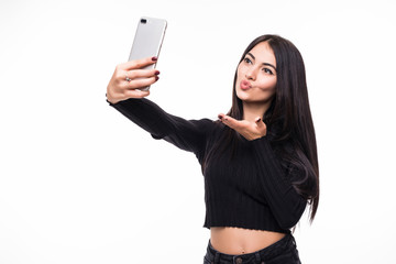 Fototapeta premium Pretty young happy woman making selfie on smartphone on white background