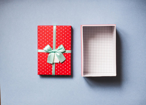 Open Red Gift With Bow On Blue Background Top View.