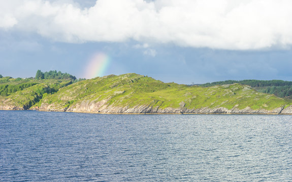 Fjordlandschaft an der Küste mit Regenbogen