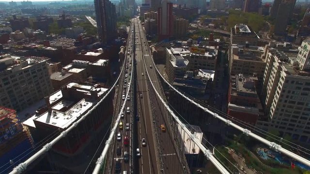 Brooklyn bridge aerial in summer, camera moving right over the bridge shooting Brooklyn view and then the top view of the bridge, cars moving across the bridge. Concept of connection.