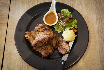 Pork chop steak on black dish