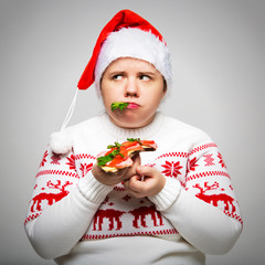 Portrait of a fat woman with a large sandwich in her hands. She is wearing a festive Christmas...