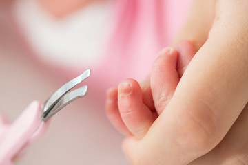 Mother cutting baby nails