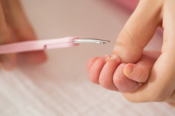 Mother cutting baby nails