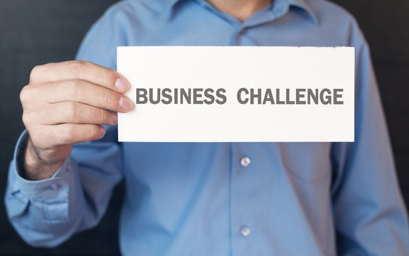 Man showing white paper with a business challenge word.