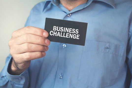 Man showing black business card with a business challenge word.