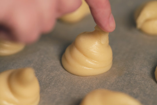 tipping choux dough for profiteroles on baking paper
