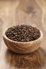fresh roasted coffee beans in wood bowl on table