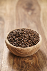 fresh roasted coffee beans in wood bowl on table