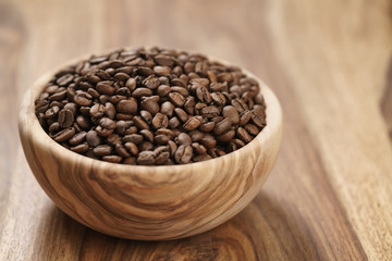 fresh roasted coffee beans in wood bowl on table