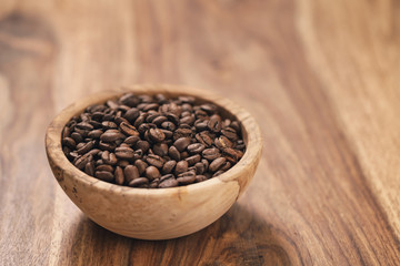 Fototapeta na wymiar fresh roasted coffee beans in wood bowl on table