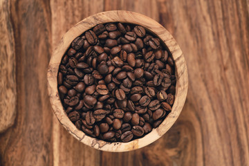 fresh roasted coffee beans in wood bowl on table