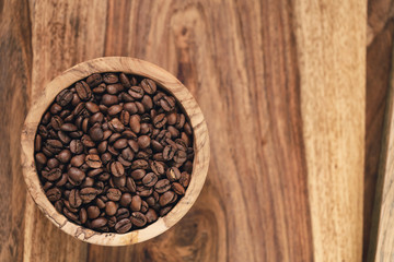 fresh roasted coffee beans in wood bowl on table