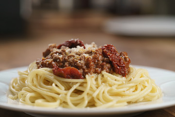 spaghetti bolognese on white plate on wood table