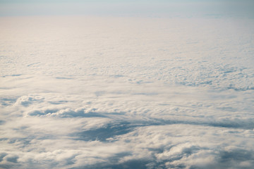 Fototapeta na wymiar aerial shot from plane flying above the clouds in daytime