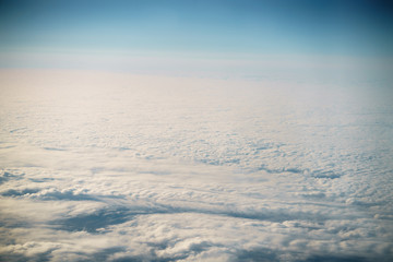 Fototapeta na wymiar aerial shot from plane flying above the clouds in daytime